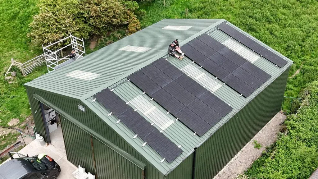 Professional solar panel installation at a rural workshop